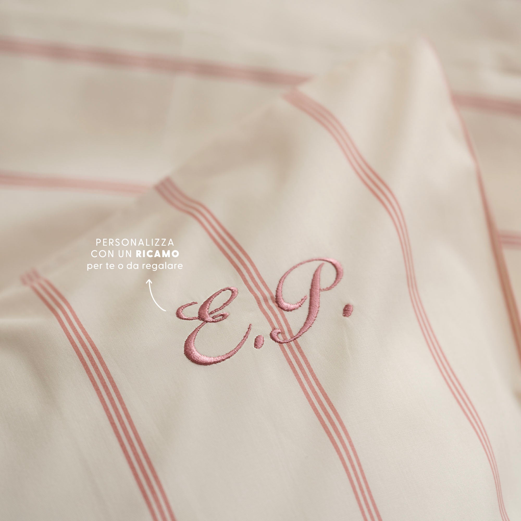 Dettaglio ricamo personalizzato su cuscino a righe crema e rosa antico Dalfilo